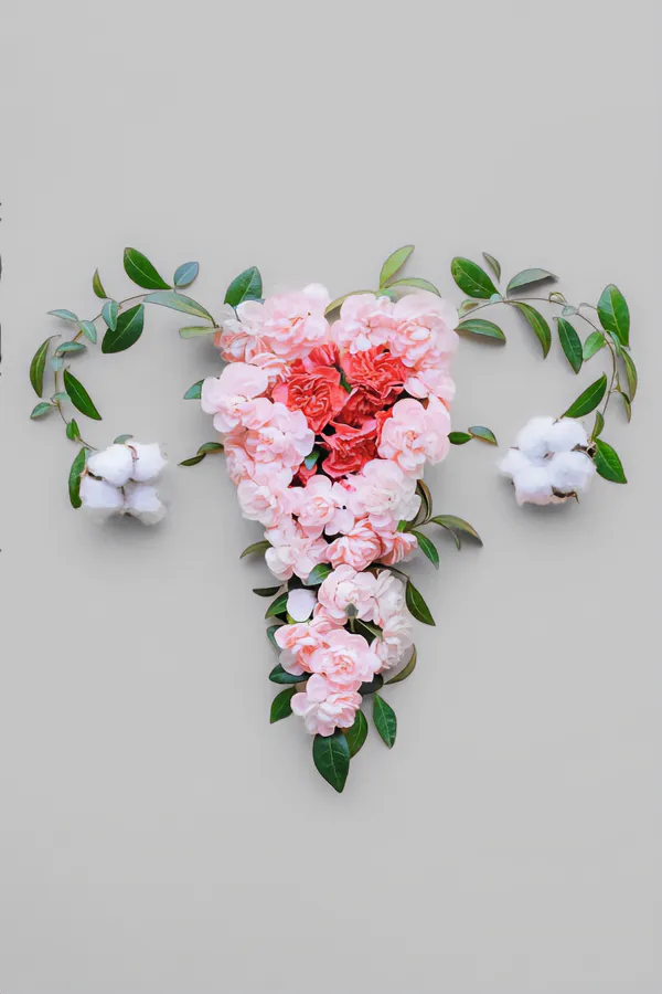Flowers on a gray background, arranged in the shape of the female reproductive system, representing Endometriosis treatment from Dr. Bahar Amin in North York.