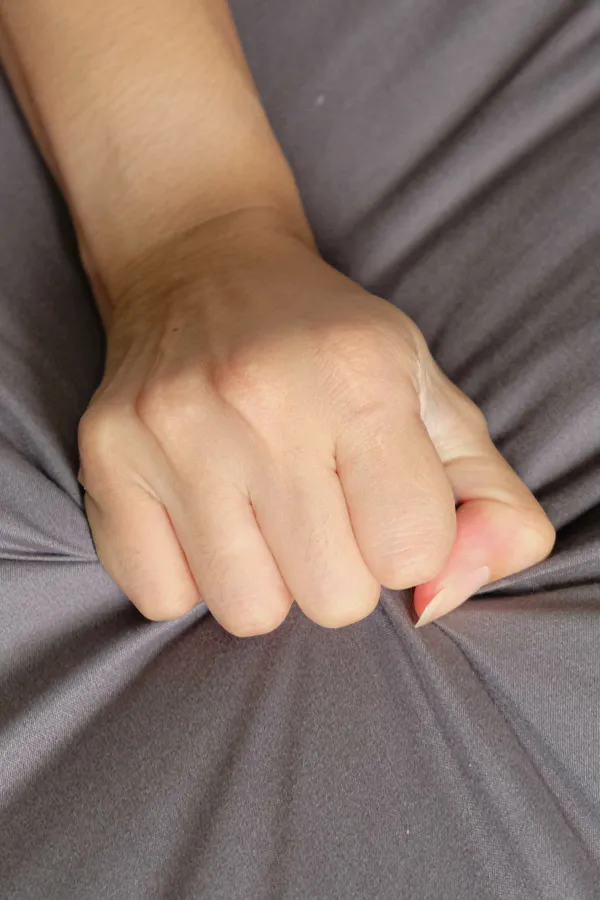 Close-up of a woman's hand grabbing a sheet, indicating sexual pleasure. Get female sexual dysfunction treatment from Dr. Bahar Amin in North York.