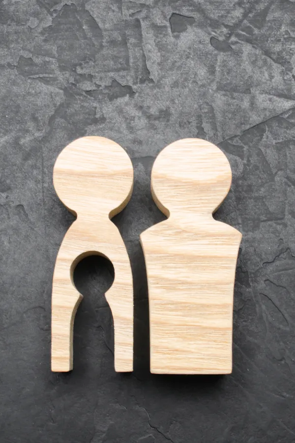 A woodblock sculpture of a small family. Get male infertility treatment from Dr. Bahar Amin in North York.