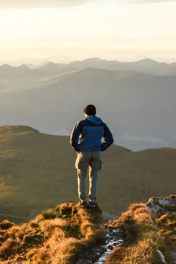 A man on a mountaintop looks out onto the horizon. Get low sperm count treatment from Dr. Bahar Amin in North York.