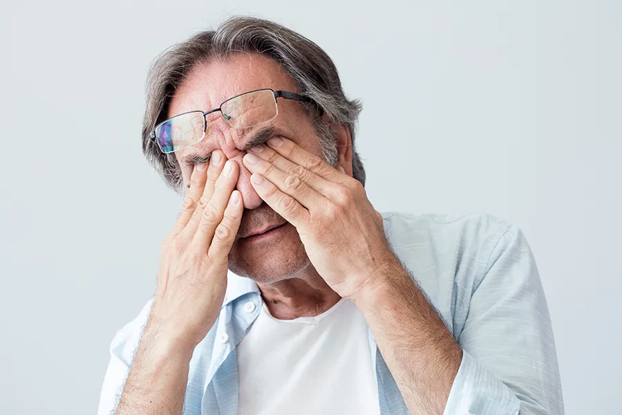 Get migraine relief with Dr. Bahar Amin's functional medicine for migraines treatment in North York, represented by an older man rubbing his eyes due to head pain.