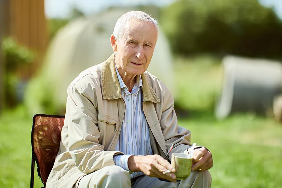 A very thin older man sits outside. Get treatment for muscle atrophy from Dr. Bahar Amin in North York.