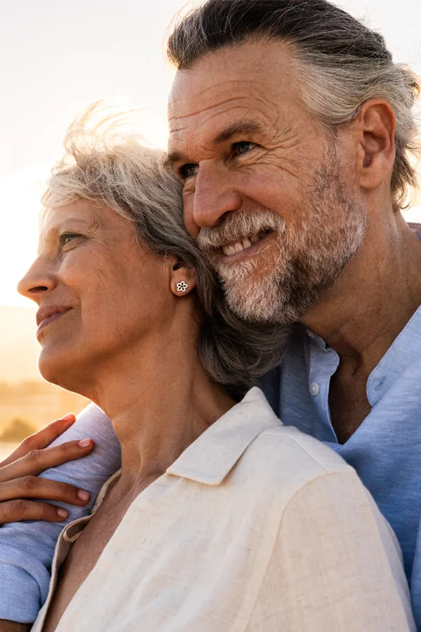 A mature couple happily look out onto the ocean. Get thyroid imbalance treatment from Dr. Bahar Amin in North York.